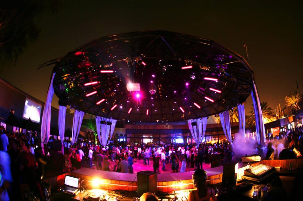 Dubai nightlife features people dancing and socializing in a trendy nightclub.